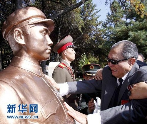 10月24日，在朝鲜平安南道桧仓郡志愿军烈士陵园，中国志愿军老战士代表团成员向旭（前右）在毛岸英烈士陵墓前抚摸毛岸英雕像。新华社记者陈建力摄